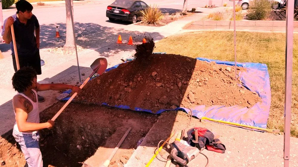 An open trench with the sewer line exposed.